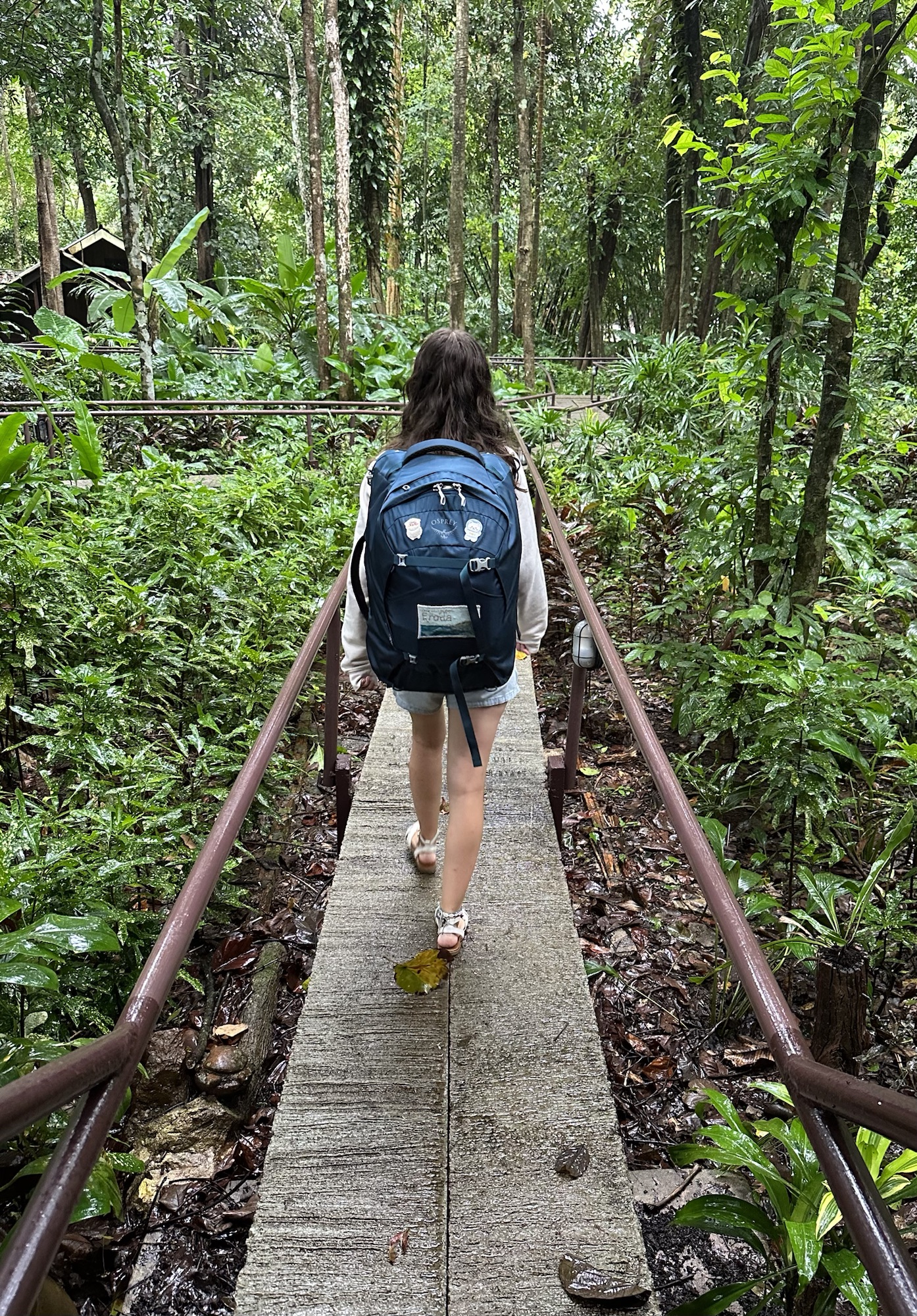 Chloe walking through the jungle with Osprey Fairview 40L backpack on.
